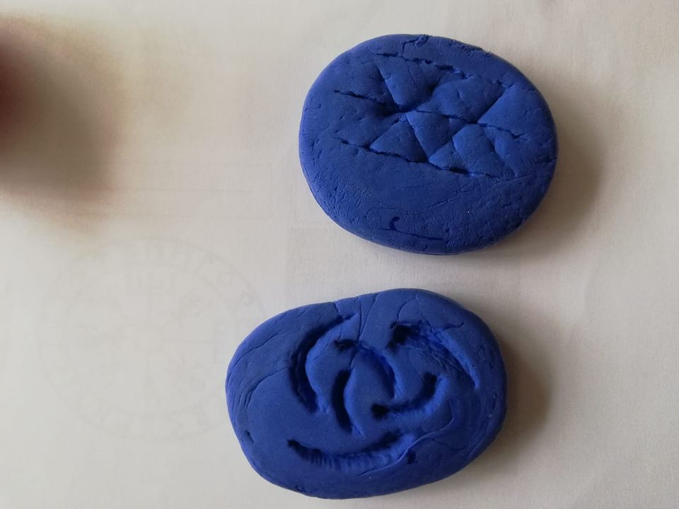 Photograph of two blue handmade clay brooches