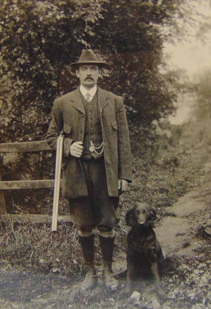 Fred Wright holding a gun, with a small gun dog seated next to him, on the Cusworth estate