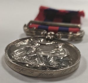circular silver medal with a red and blue ribbon