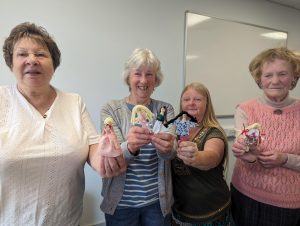 Four women with their crafted peg dolls