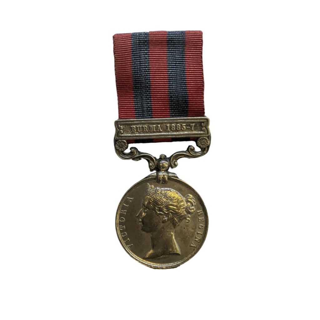 silver circular medal on red and navy blue striped ribbon
