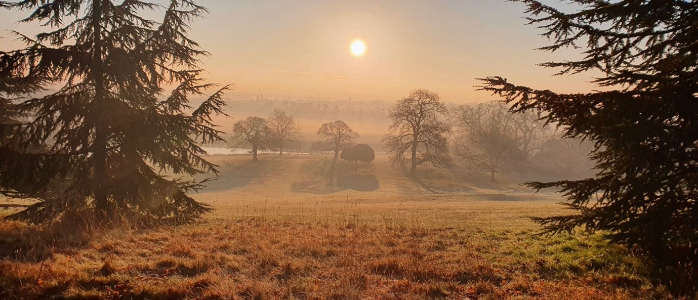 Misty, sunrise view from top of a hill looking down to the lake